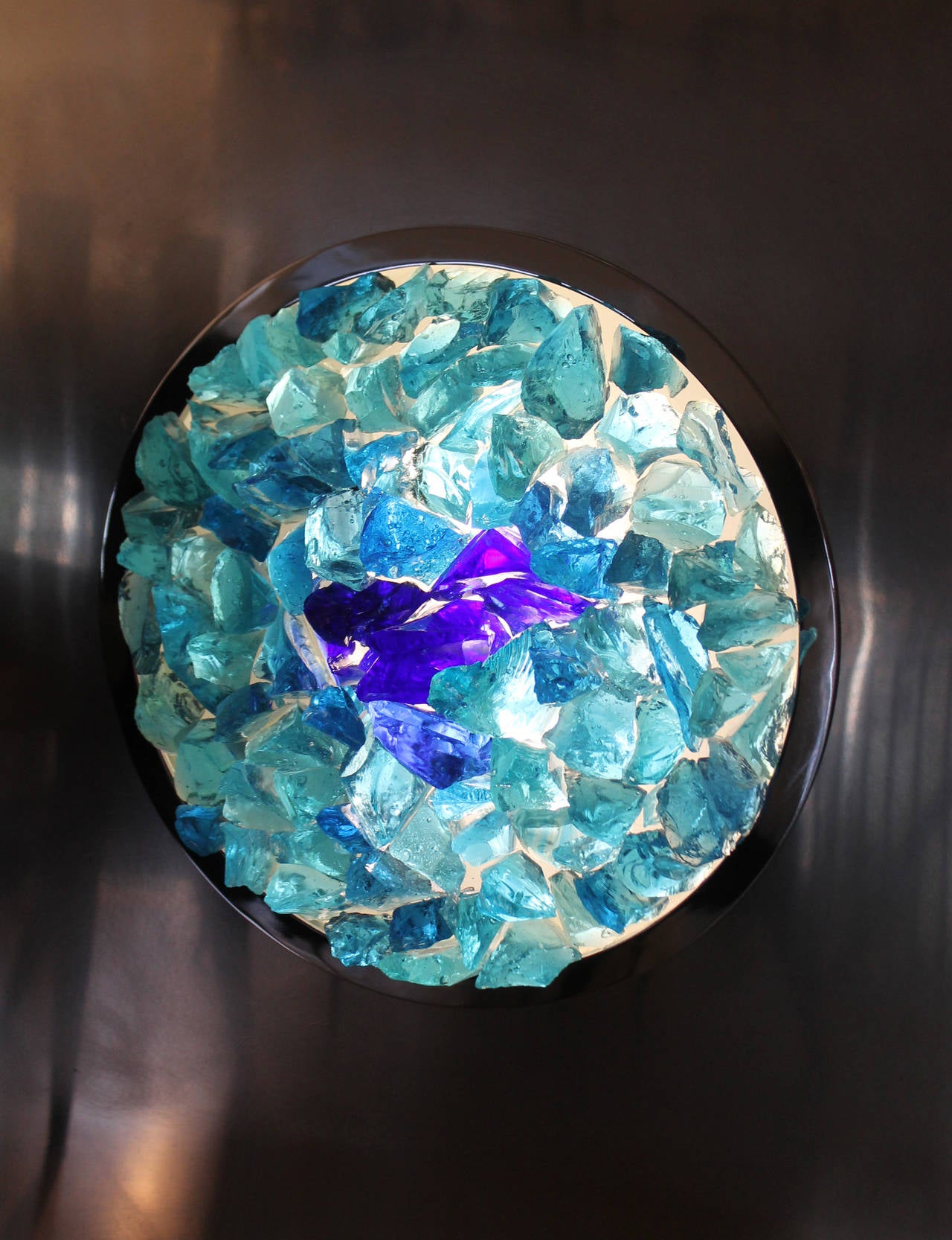 Striking work by Italian Artist Angelo Brotto whose works are also in the Museums of Modern Art of Rome and Venice. It is composed of a steel square with a blue glass gem filled circle at the center. The glass gems vary in color and are back lit.