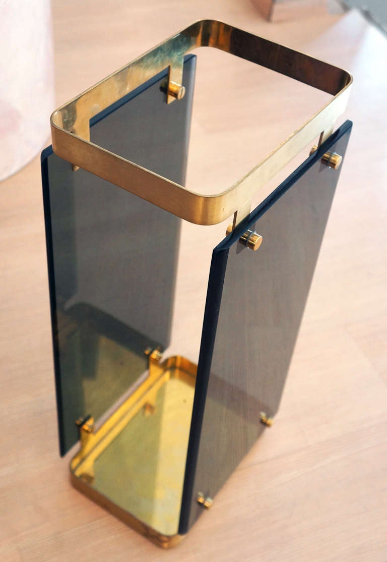 A nice Fontana Arte umbrella stand of the 60's featuring two smoked glass slabs held together by a thick brass upper and lower part.  For the same piece see Cambi Auction House catalogue 12/18/2012 lot 661 mentioning its representation on one of the