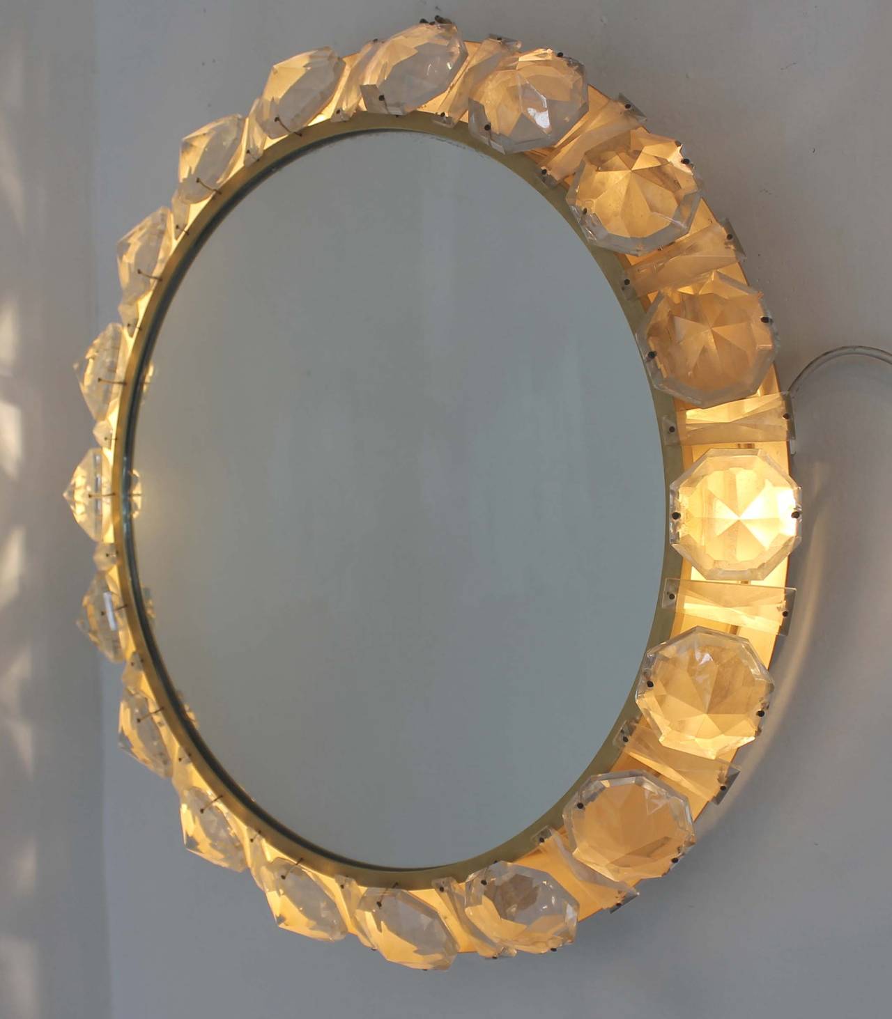 This eye-catching piece by Bakalowits & Sohne is backlit with four candelabra sockets which allow the glass diamond crusted edge to light up. The back and frame are brass. The manufacturing model is 4338.