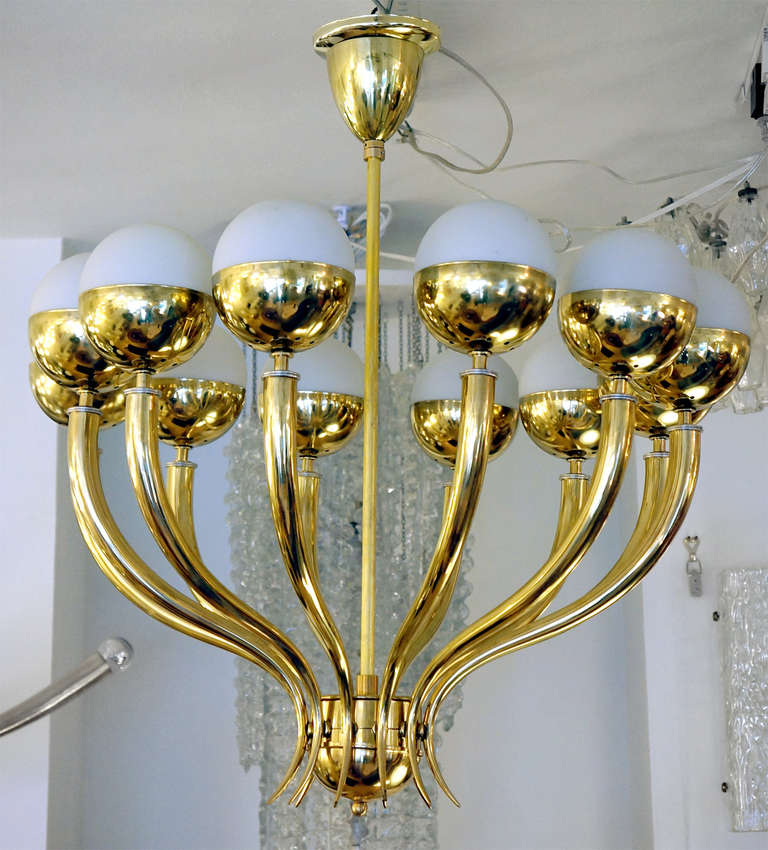 Brass chandelier from the late 1940s-early 1950s clearly showing the transition from more classic design to the midcentury one. The result is striking: a chandelier that has the best of both worlds. In arms each holding a sphere with a socket. Very