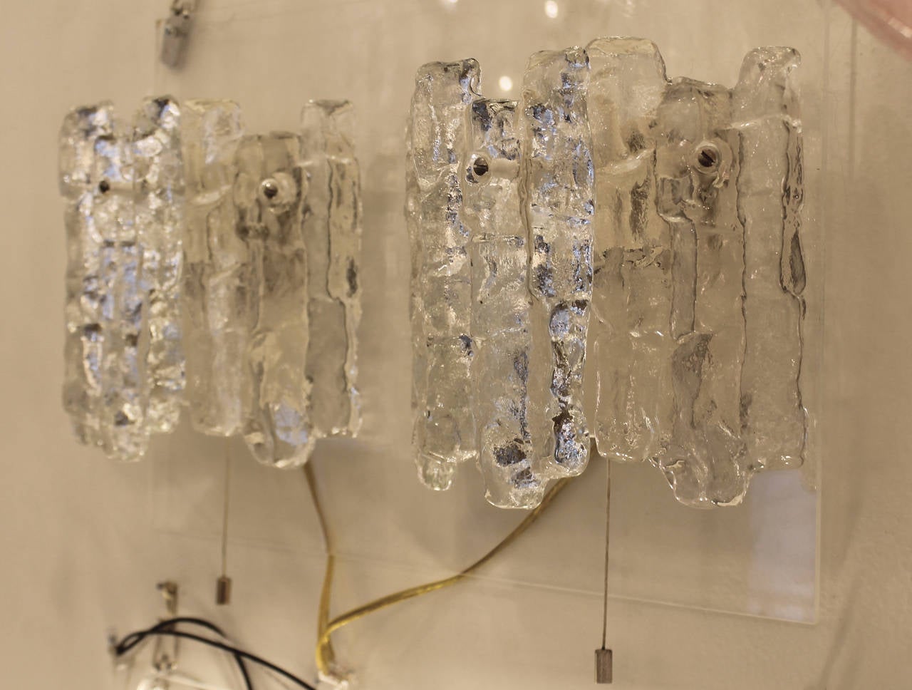 Each sconce features three icicle textured glasses and two sockets with a pull switch.
