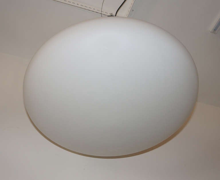 Minimalist and elegant pair of large Stilnovo lighting pieces featuring pure white horizontally elongated pendants. Pendants hang from a black painted  canopy. For the same pendant see Philips the Pury catalogue Design Auction London April 2013 lot