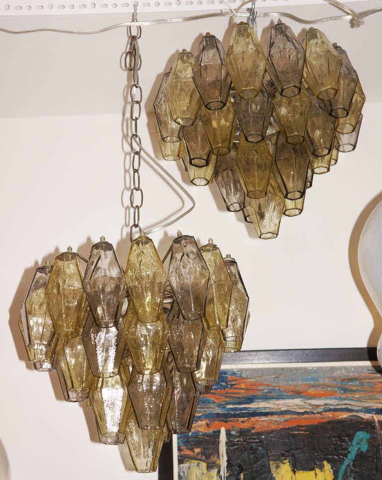 Designed by Carlo Scarpa the polyhedral chandelier reached a tremendous success and became the image of Murano creativity in lighting. This example features two sockets and four levels of polyhedral glasses  pale amber/green and gray. Remains of the