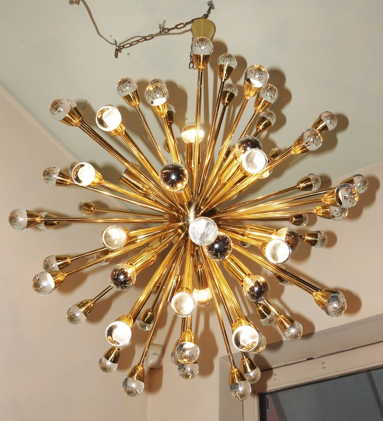 The central brass sphere launches numerous rods of different length ending in full glass spheres. 16 light sockets. Hand made 1n a limited edition by craftsman Fedele Papagni in Milan. The central stem can be made longer or shorter reducing the