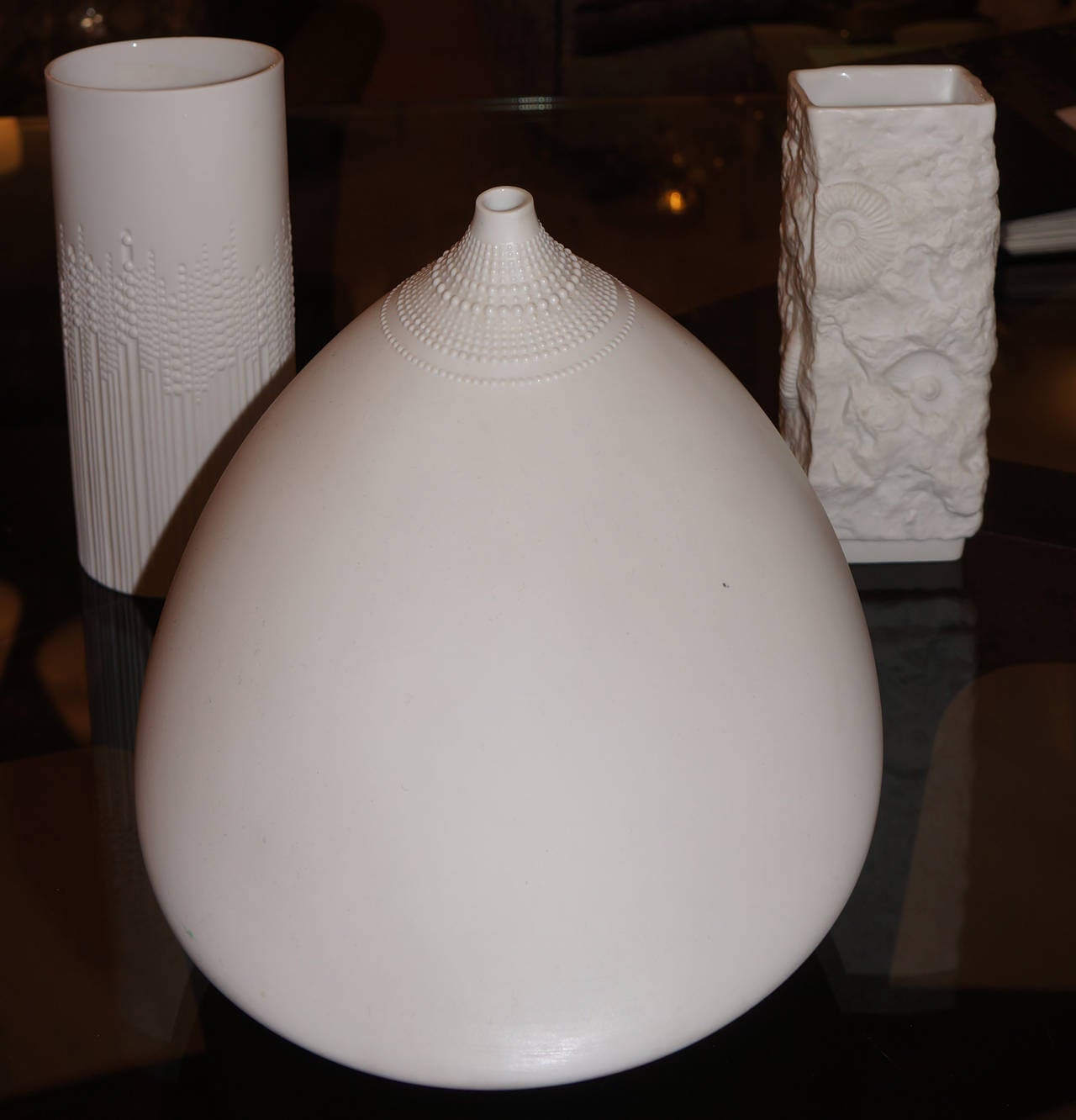 Balanced group of three German, Mid-Century white porcelain vases . Two,  the largest one and the tall oval one, are by Tapio Wirkalla for  Rosenthal. The third vase with fossils engraved was made by Kaiser, another well know German pottery maker.