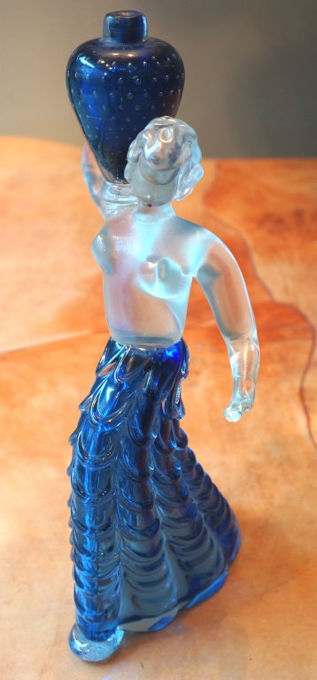 A close look shows the exceptional quality and workmanship of this sculpture. Iridescent clear glass body and head. Rich blue long skirt and 