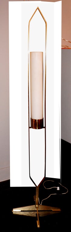 This unusual Italian floor lamp is made of an elongated solid brass structure framing a cylinder of white sanded glass. The cylinder hides one regular socket.

