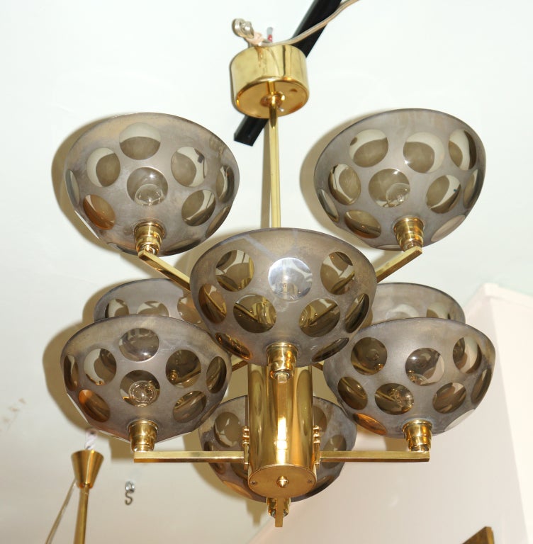Unusual Stilnovo chandelier made with eight thick grey glass cups held by a brass frame. The circles on the glass cups were created via a sanding process. Height can be adjusted upon request.

Available for viewing at Gaspare Asaro-Italian Modern in