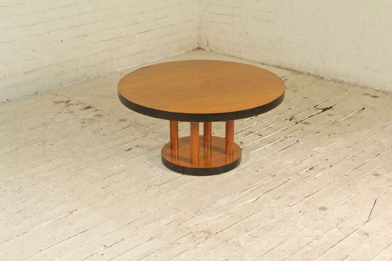 This well-proportioned Italian-style coffee table, features a stable, solid wood construction, gorgeous blonde walnut veneer, four columnar legs, and bold, ebonized-lacquer edges. Despite its small stature, this table feels definitively-monumental;