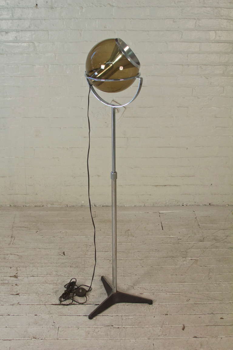 Directional floor lamp with extendable chromed-steel shaft, adjustable tinted-glass globe, and cast iron base. Designed by Frank Ligtelijn for RAAK of Amsterdam.