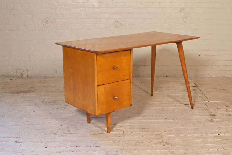 Single-pedestal, two-drawer desk in solid Maple by Paul McCobb. Conceived for his signature Planner Group collection for Winchendon Furniture Company, this timeless design features a very sturdy, completely-demountable construction,