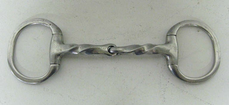 Beautiful eggbutt snaffle bit with slow twist center in stainless steel. This handmade piece can be used as an interesting paperweight or accent on any bookshelf. The item has been stamped 