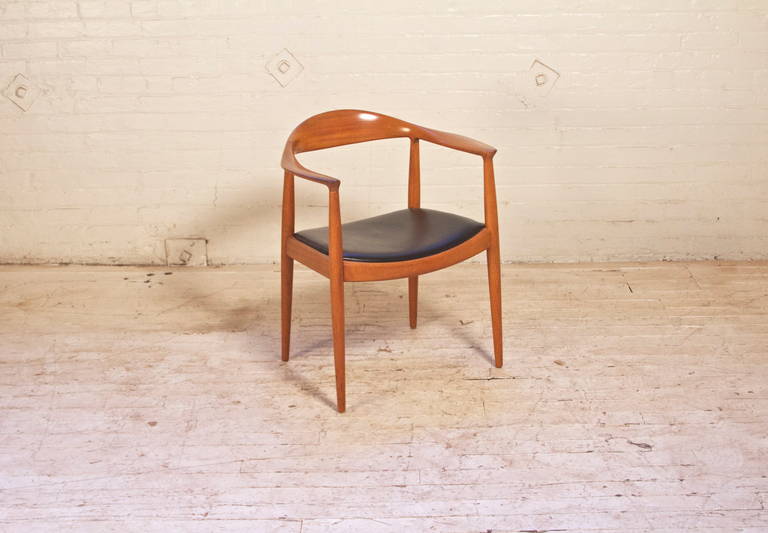 Vintage round chair by Hans Wegner for Johannes Hansen Cabinetmaker with Teak frame and original black leather seat. First designed in 1949, this is a great example of a classic chair-stamped Johannes Hansen.