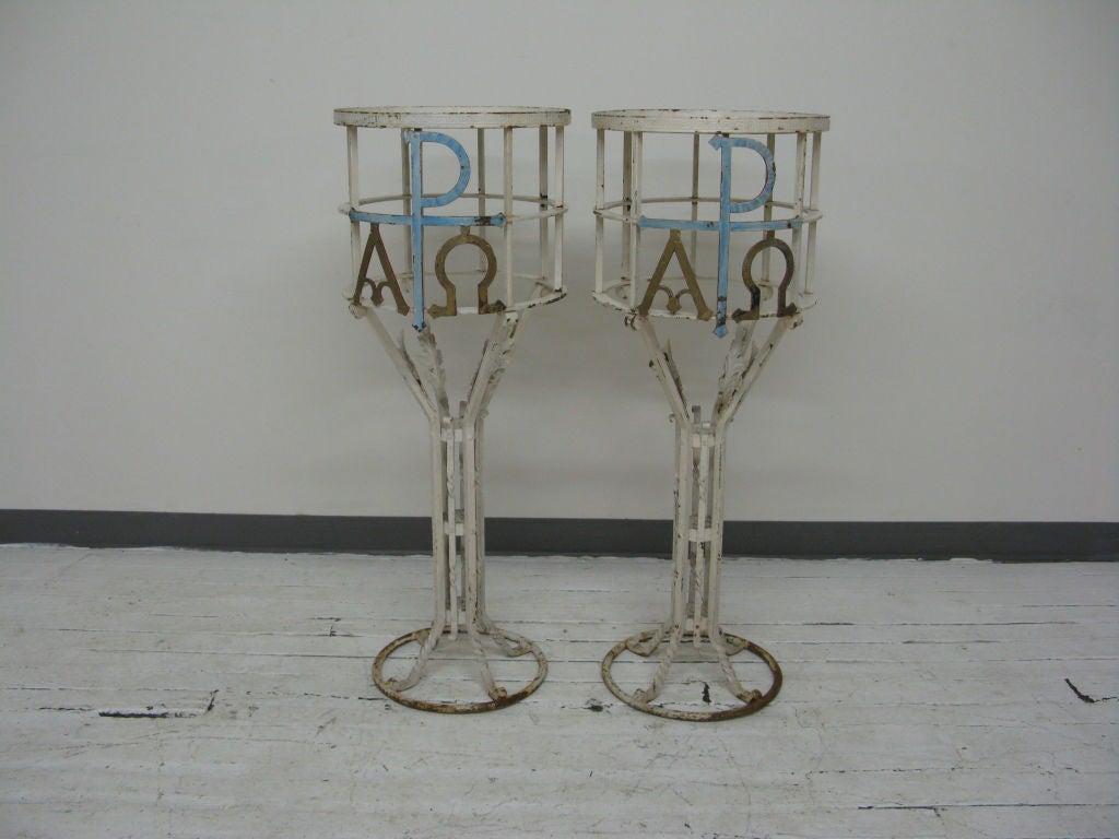 Piédestaux en fer forgé de grande taille et attrayants, fabriqués sur mesure et peints en blanc, avec logo grec et décoration de feuilles d'acanthe.