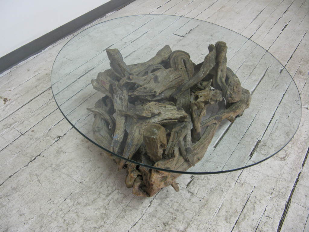 Very attractive old natural root tree base coffee table with original round glass top mounted on wheels.