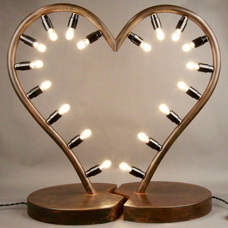 These heart-shaped lighting fixtures combine art and functionality in a dynamic piece to accent your home décor. The urban feel of the vintage distressed bronze molded to create the frame is softened by the romantic curvature of the heart shape. The