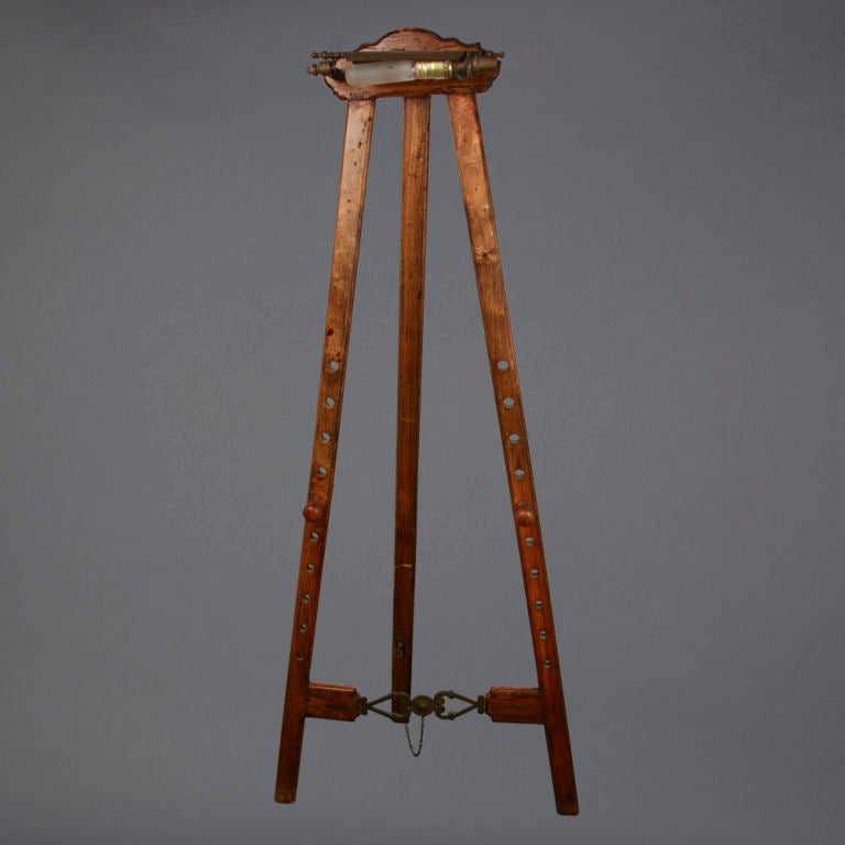 This handsome British antique painting easel is an original piece from the 1800's. This piece is crafted from pine wood, giving the frame an exquisite and textured appearance. An impressive and authentic addition to your home decor, this antique is