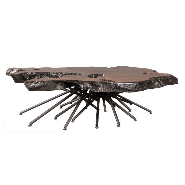 This custom made coffee table was crafted at the hands of our specialized in-house artisans. The welded metal base supports a reclaimed redwood face that has been hand burnt to naturally accentuate the color and is completed with a satin finish. The