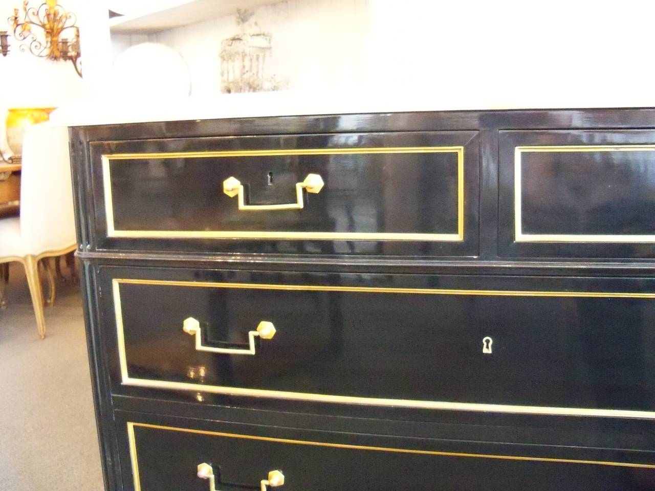 Directoire style black lacquer commode, in the manner of Maison Jansen, France, circa 1940 with conforming white marble top and four drawers bound with bronze trim and pulls.