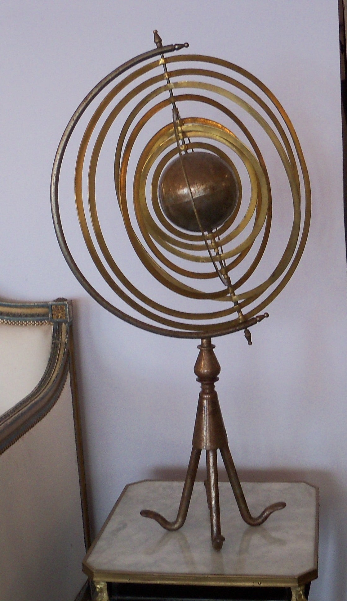 Visually arresting Italian steel and brass armillary sphere, circa 1900. There is a central steel globe and nine graduated concentric brass rings which rotate on a central axis, held in place by a stationary semicircle which is raised on a steel