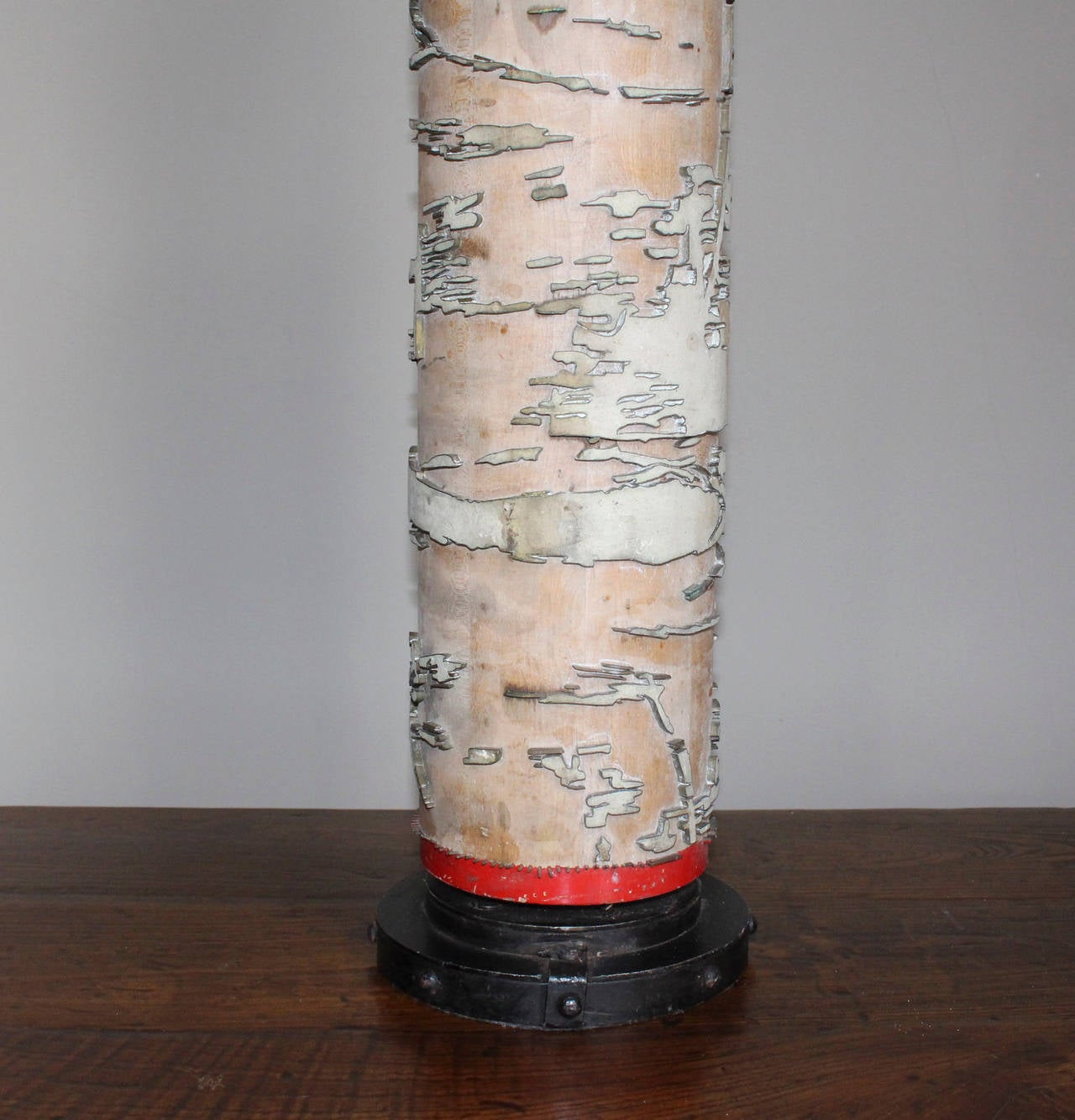 Vintage table lamp built from a repurposed wallpaper print roller bordered with red painted trim and standing on metal base detailed with rivets. Lamp measures 38