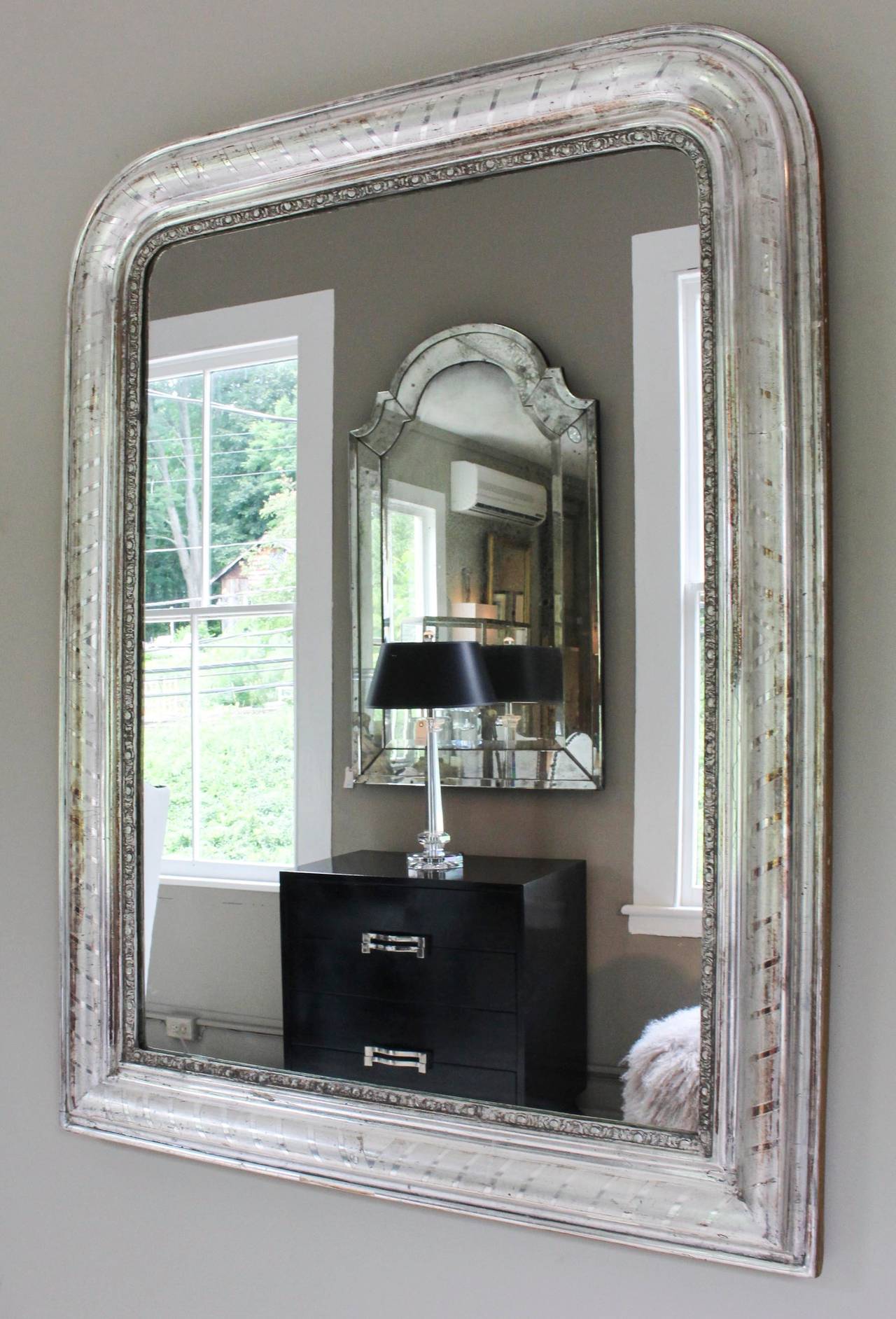 Classic Louis Philippe mirror, 19th century France, in silver gilt on gesso with mitered stripe moulding and elaborately craved spacer.