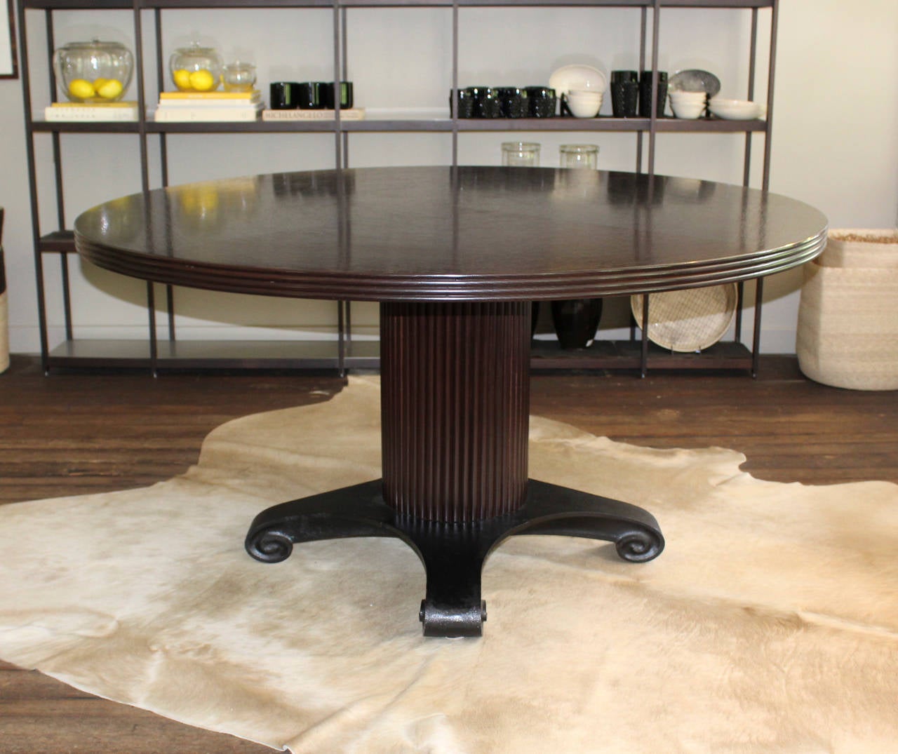 Angelo Donghia ebonized table supported on ridged pedestal with scroll footed iron base.