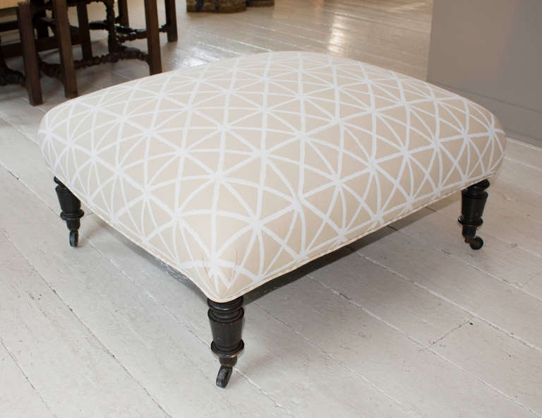 Napoleon III ottoman, France, 19th century, raised on ebonized turned legs with casters, newly upholstered in a neutral block print cotton from Madeline Weinrib.