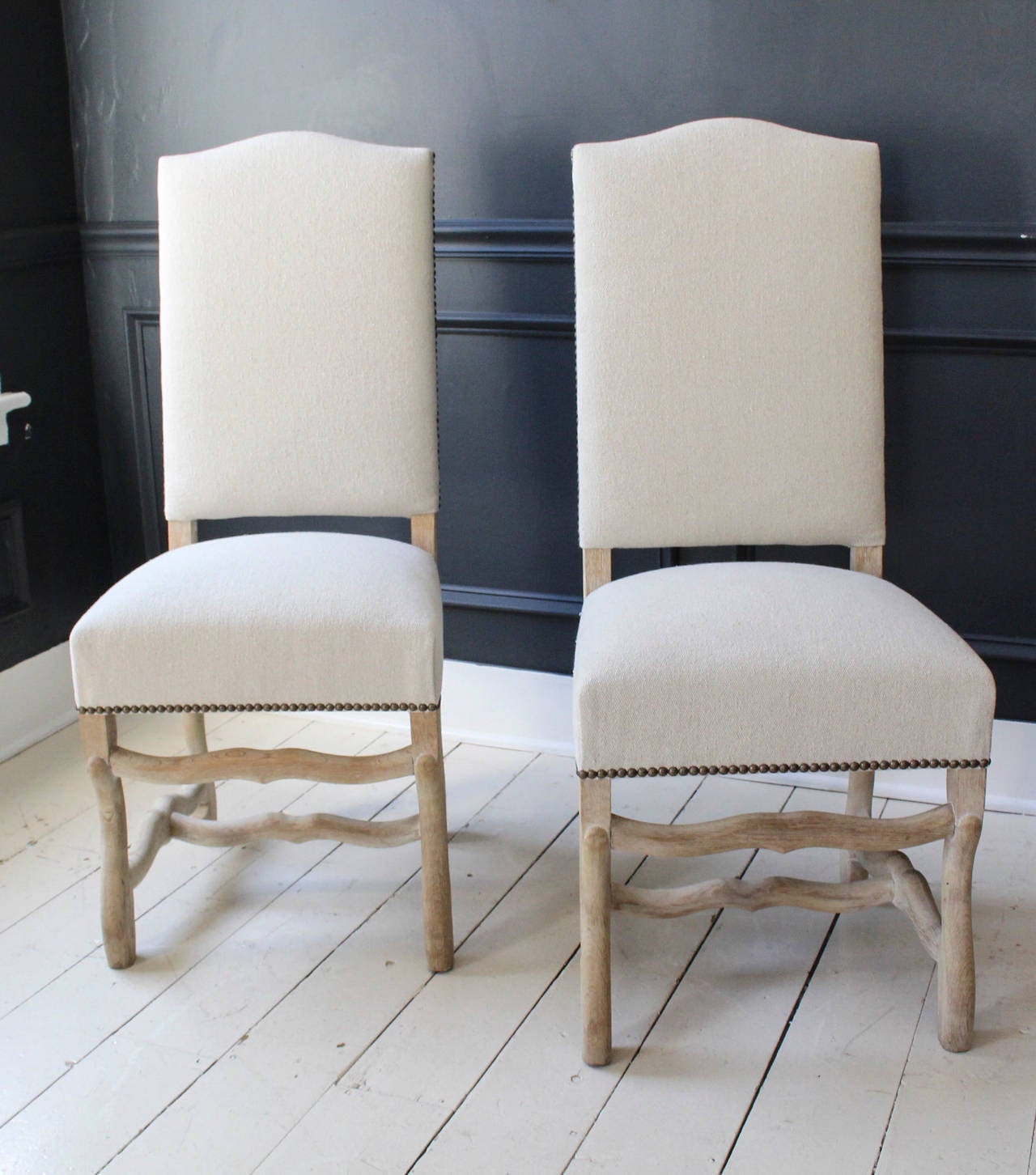 Set of six Os de Mouton dining chairs, early 20th century France, on bleached oak frames upholstered in natural textured cotton detailed with antiqued brass nailheads.