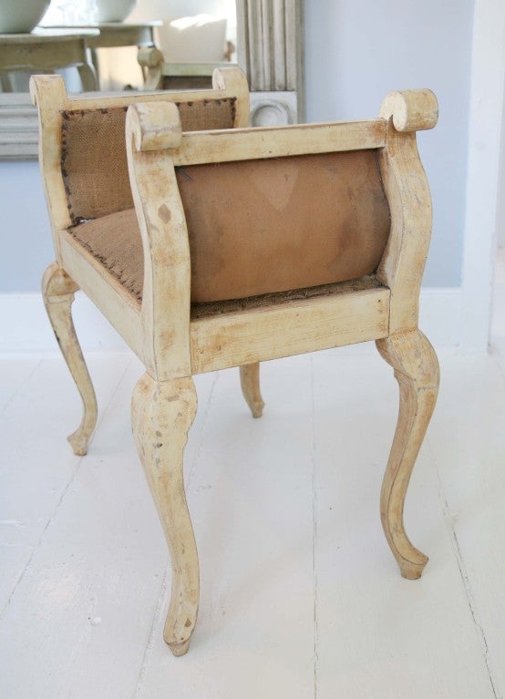 Charming antique French bench in oyster paint with scroll arms and bowed legs. Seat and sides in raw burlap.