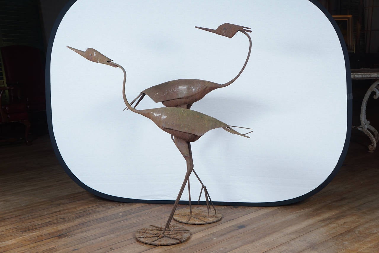 pair of metal sculpted Herons / each with differing animated pose / heavily rusted patina / from a garden