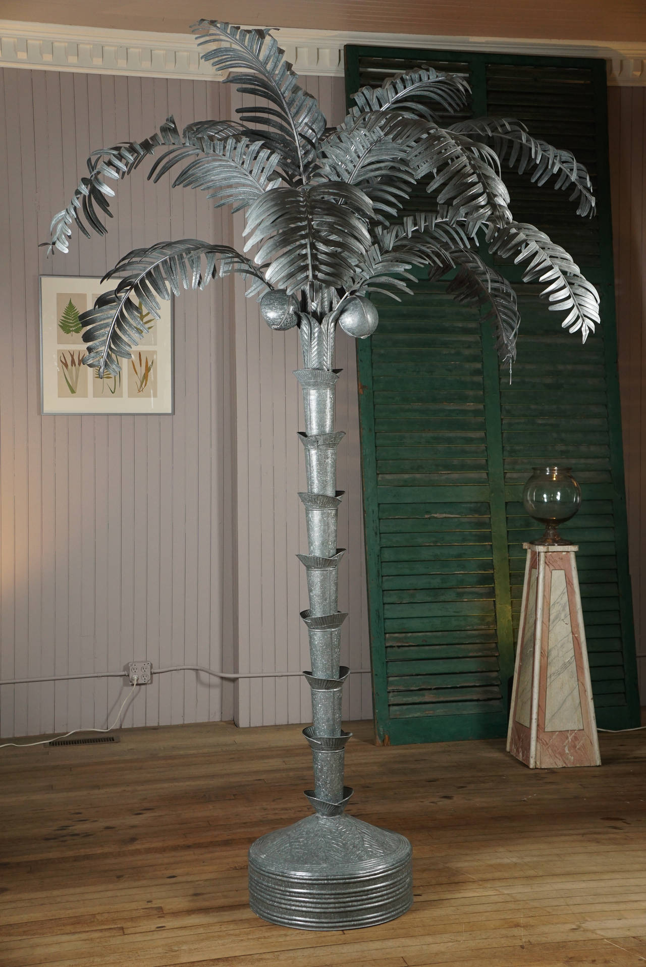 Oxidized galvanized tin palm tree. Weighted base, two part trunk, eight large fronds, crowned with four smaller fronds and three coconuts. Assembled as you wish.