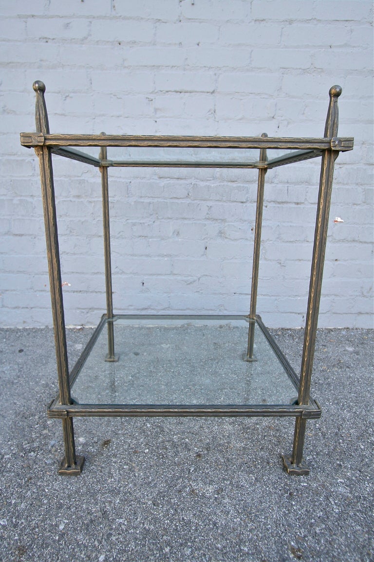 A pair of Italian two-tier iron side tables with clear glass tops. Signed Claudio Rayes. In the style of Giacometti.
