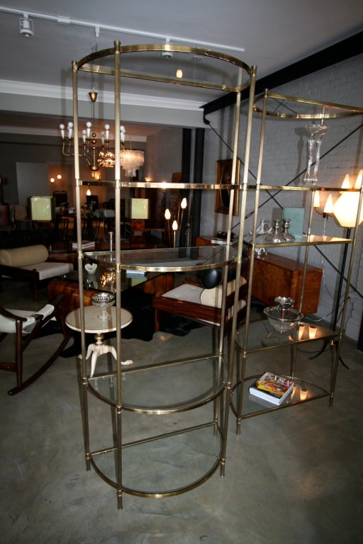 Pair of 1940s French half moon brass etagere with five glass shelves each.<br />
<br />
Please call or use the contact dealer link below to reach us directly with any questions regarding this item. We are happy to obtain delivery quotes from our
