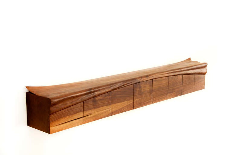 Tree trunk sideboard by Bryan Drinchich made of walnut to look like a fallen log.  Features three cabinets with two shelves each.  Tapers from 11