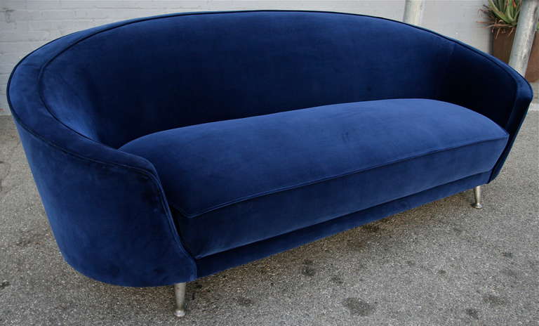 Italian curved sofa from the 1960s in the style of Ico Parisi upholstered in cobalt blue velvet with metal legs.