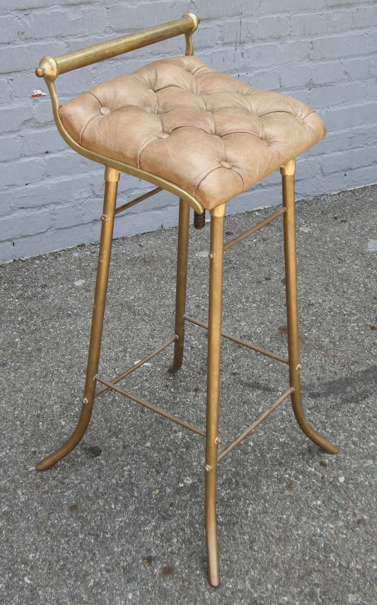 Pair of 1950s French leather and brass bar stools with adjustable seat. Priced individually.  Height of the back of chair ranges from 29.5- 32.5''. Seat height ranges from 26.5-29.5''.