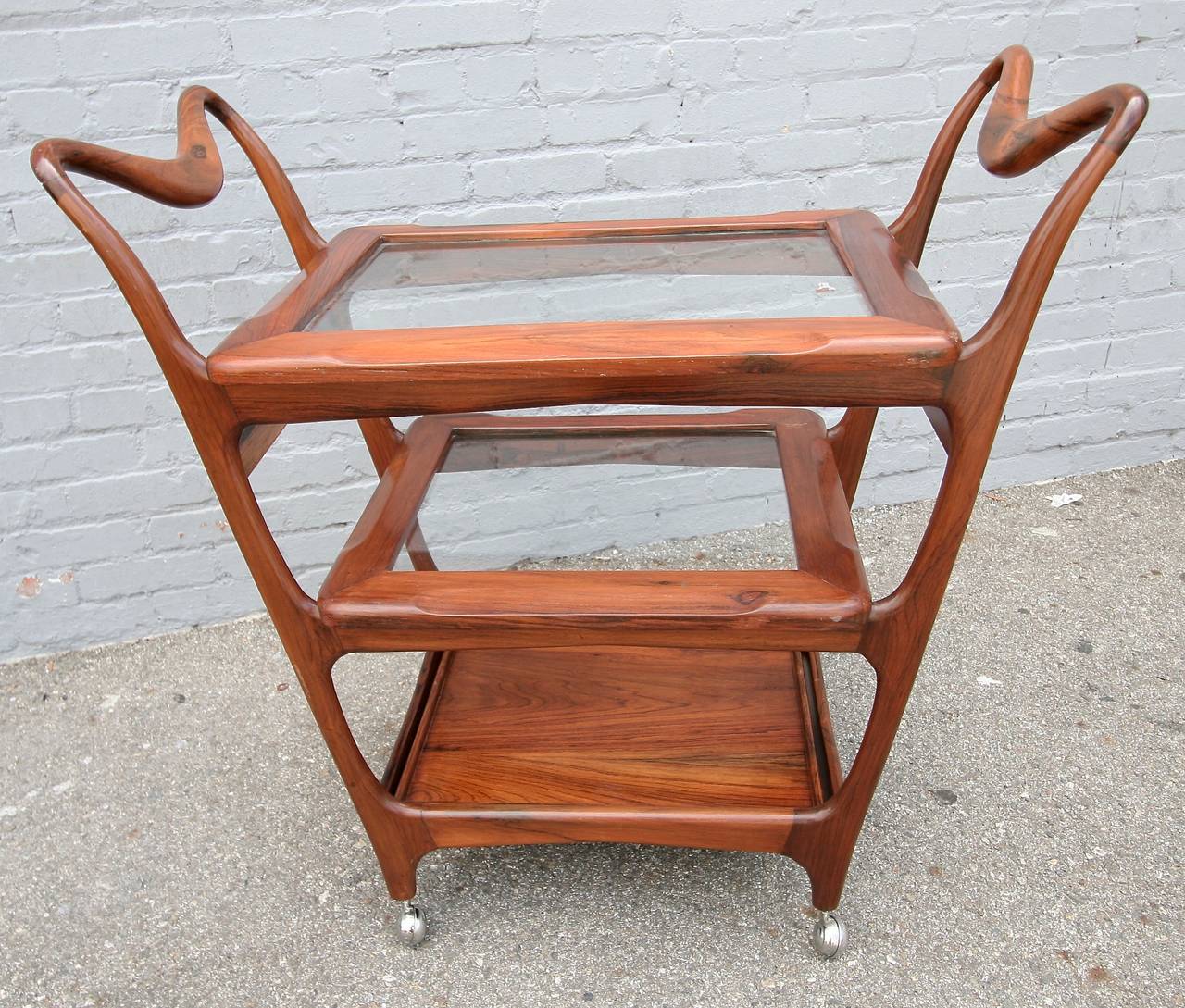 Brazilian jacaranda wood bar cart by Carlo Hauner from the 1960s with three shelves, all of which also serve as trays, two with glass and one in wood.