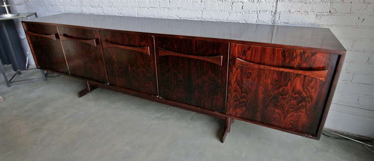 Brazilian jacaranda sideboard by L'Atelier with bow tie handles. Two end cabinets feature a single shelf. The middle cabinet contains four drawers.