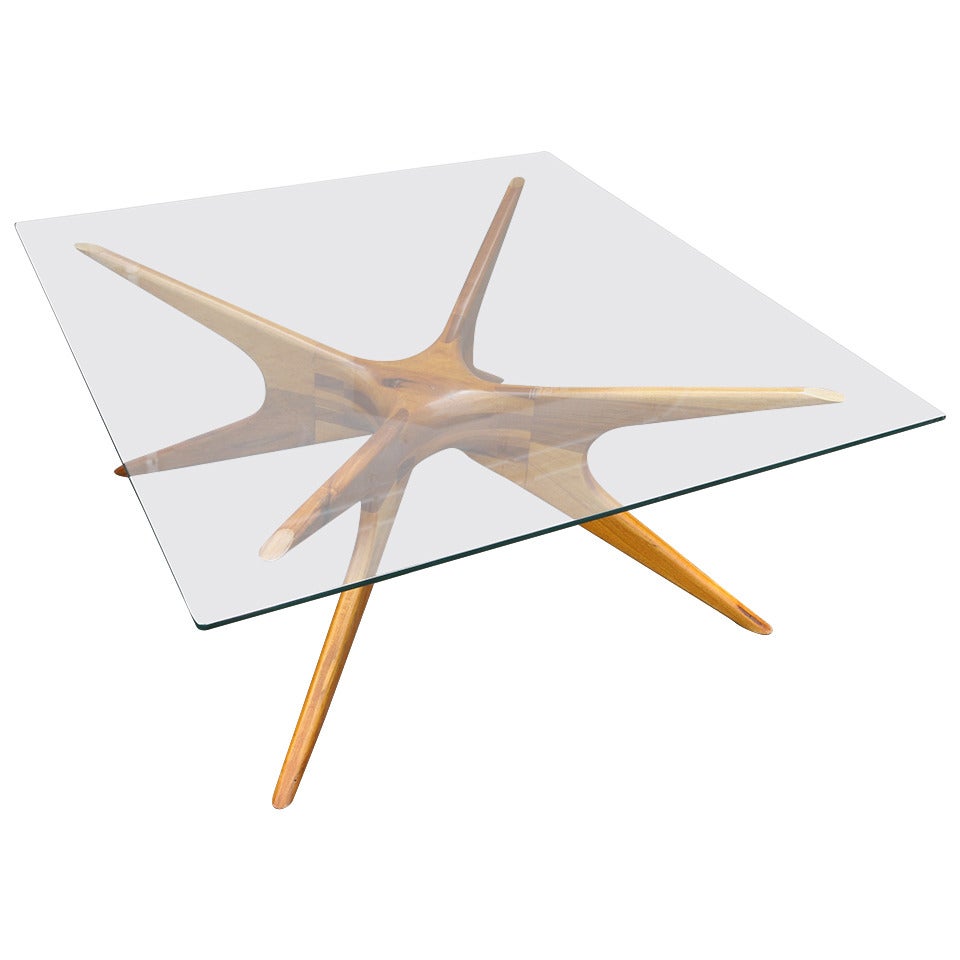 Argentinian coffee table with spider leg base in Petiribi wood with glass top.