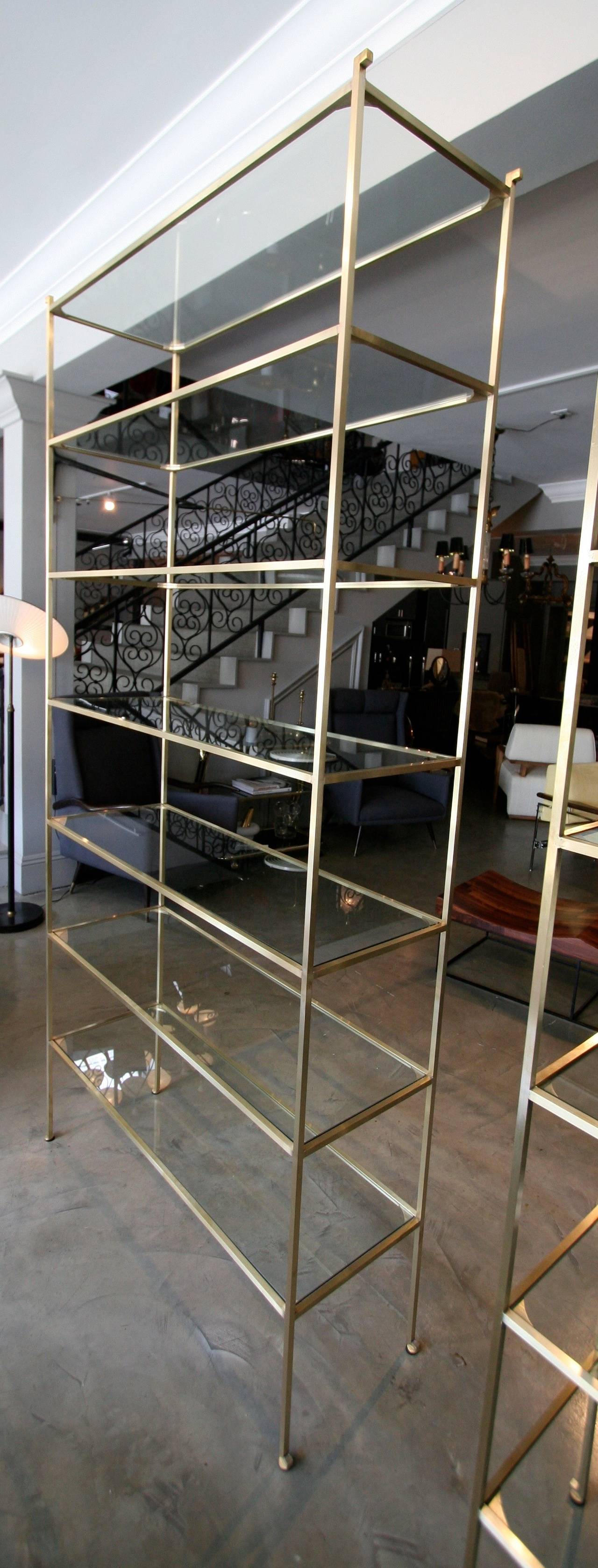 Tall custom brass étagère with seven glass shelves.  Handmade in solid brass in Los Angeles by Adesso Imports. Can be made in custom size and finish. Priced individually, not as a pair.