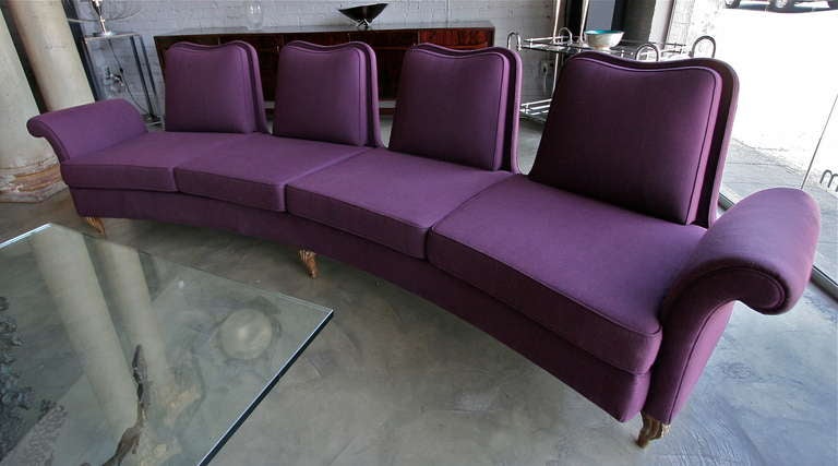 Curved four seat sofa with individual backs and carved wooden legs, upholstered in purple linen.

Please use the contact dealer link below to reach us directly with any questions regarding this item. We are happy to obtain delivery quotes from our