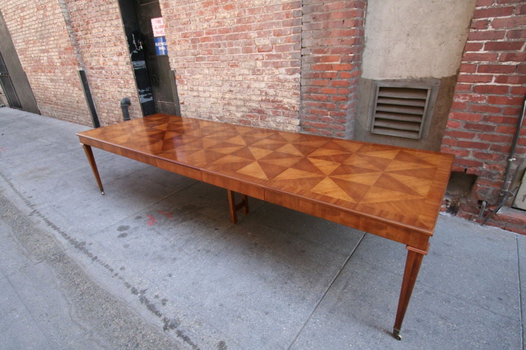 60's extendable dining table on wheels for twelve by Baker Furniture. The table has three leaves, each 21 inches wide, with a leg in the middle for additional support.

Please call or use the contact dealer link below to reach us directly with any