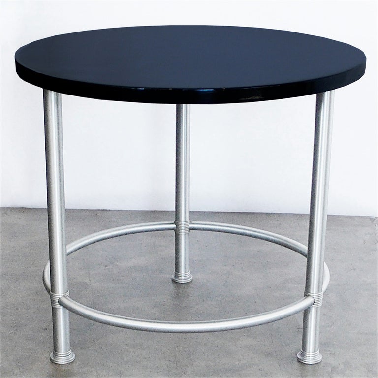 This great McArthur round table can be used for a cocktail table or a side table. The metal retains it's excellent original finish. The wood has been restored in hand polished high gloss black lacquer.