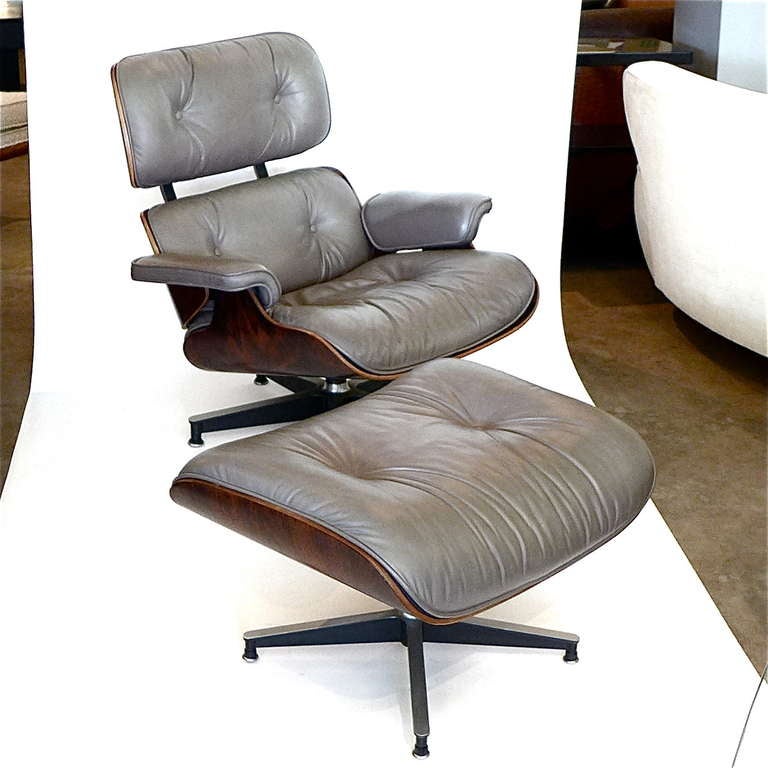 This is an original early 1970's Eames chair & ottoman with rare custom original taupe grey leather and beautiful rosewood veneer. It is a beautiful example. With down & foam filled cushions, original subtle leather, rubber back gromets and an early