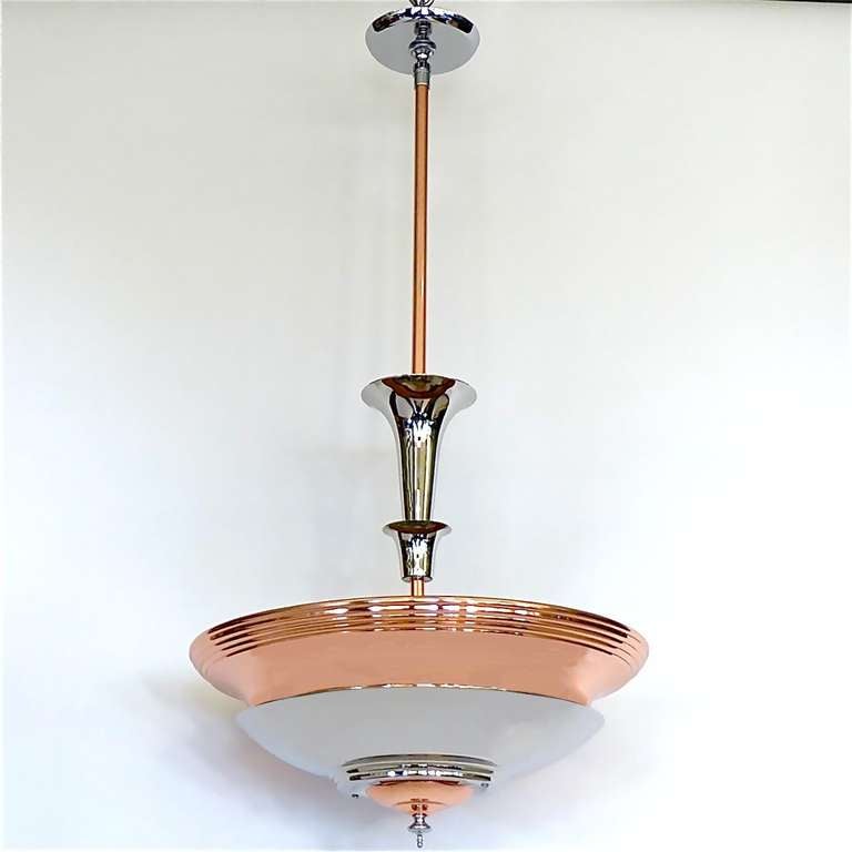 This pair of original1930's streamline Art Deco chandeliers are great for an area when indirect lighting is required. These multi tiered copper and nickel chandeliers have 2 sockets for light bulbs. Each tier is lit by the space between tier below.