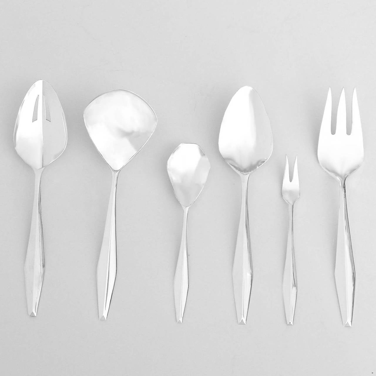 This wonderful sterling silver flatware service was designed by Gio Ponti and produced by Reed and Barton in 1958. There is a complete seven-piece table setting for twelve people plus six beautifully designed serving pieces. Each piece fits
