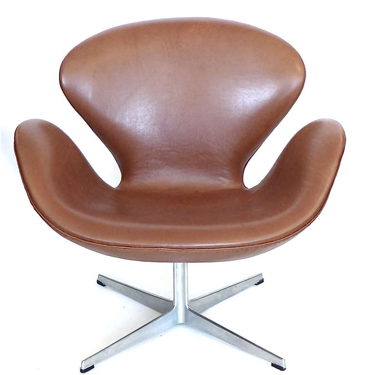 These original swan chairs are covered in vintage milk chocolate brown leather. They have the Fritz Hansen logo and 