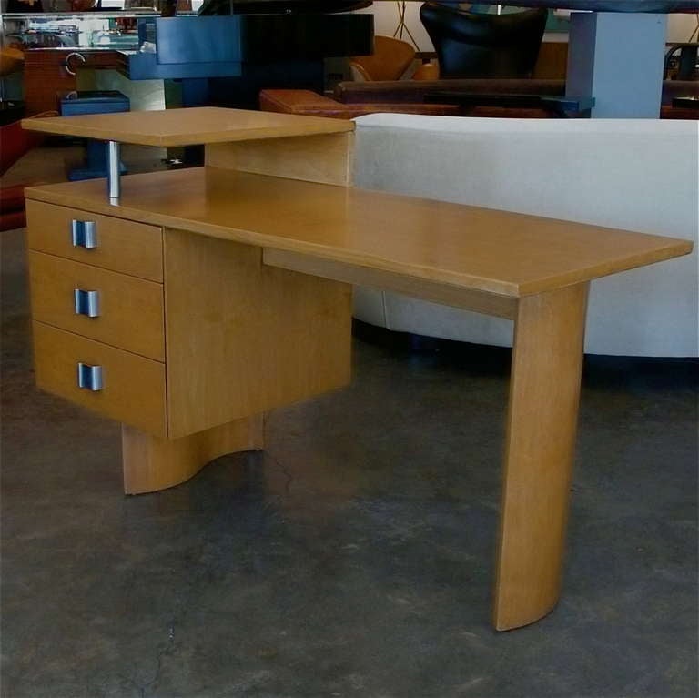This outstanding original birch desk by Eliel Saarinen has great lines. The wave base and handles present a strong contrast to the asymetrical angled floating body. 