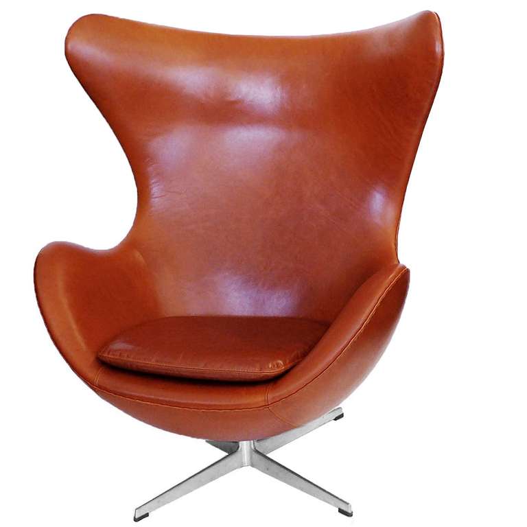 This is a beautiful vintage Danish chestnut brown leather egg chair and ottoman. Designed by Arne Jacobsen and produced by Fritz Hansen, this chair has the Fritz Hansen molded stamp impressed in the metal base. The leather is soft and pliable with